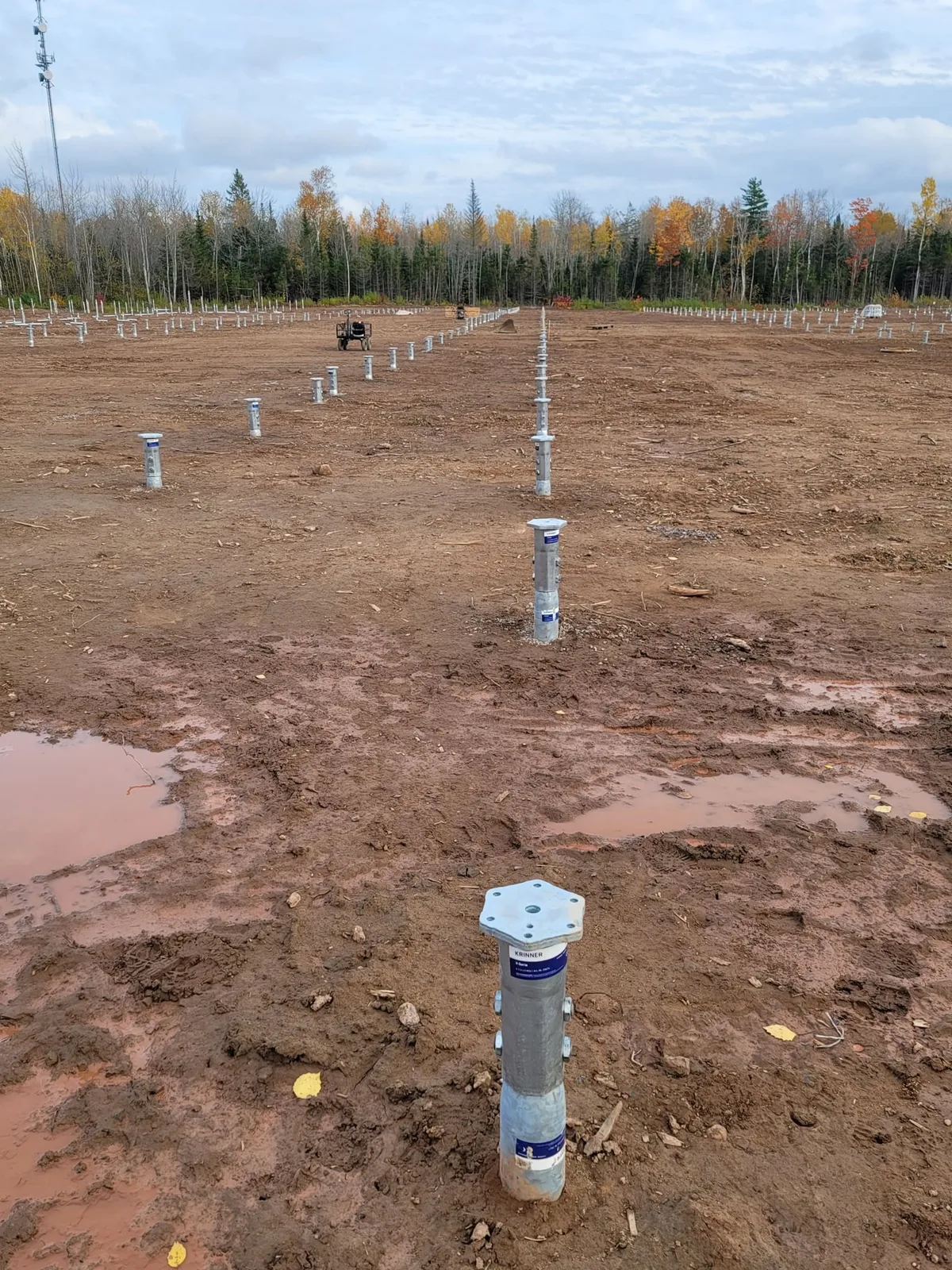 Rows of ground screw piles set across a large commercial solar site