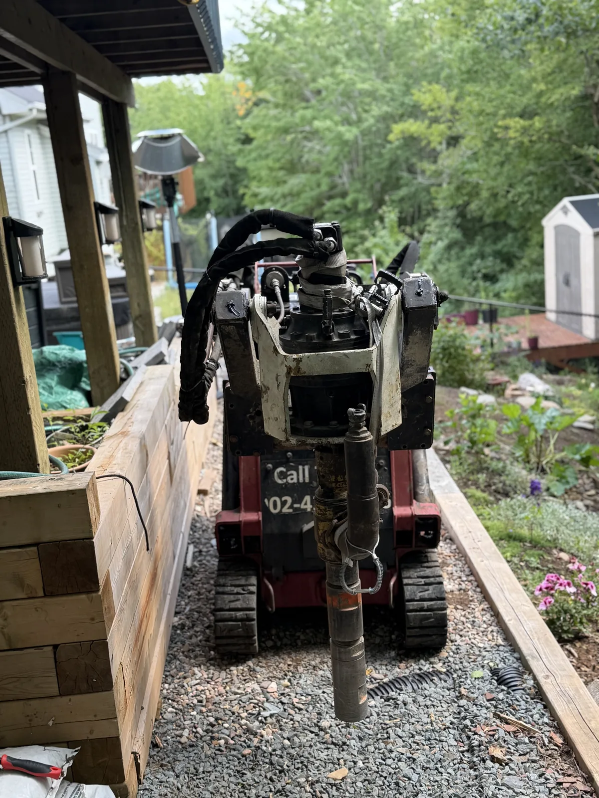 Compact ground screw rig working a narrow side yard